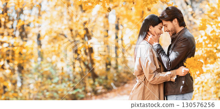 Romantic couple hugging and talking about love, dating in autumn park, copy space 130576256
