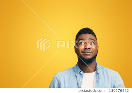 You must be kidding me. Cynical african american guy looking upwards at copy space on yellow studio background, panorama You must be kidding me. Cynical african american guy looking upwards at copy space on yellow studio background, panorama 130576432