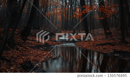 A tranquil stream winds through a dense forest adorned with autumn leaves. The water reflects the overcast sky, while trees stand tall, creating a serene atmosphere perfect for contemplation. A tranquil stream winds through a dense forest adorned with autumn leaves. The water reflects the overcast sky, while trees stand tall, creating a serene atmosphere perfect for contemplation. 130576895