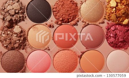 An assortment of pressed eyeshadow pans showcasing various warm shades, including deep browns, soft pinks, and shimmering golds, elegantly arranged on a smooth neutral surface. An assortment of pressed eyeshadow pans showcasing various warm shades, including deep browns, soft pinks, and shimmering golds, elegantly arranged on a smooth neutral surface. 130577059