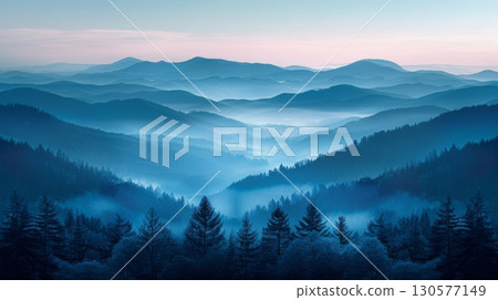 A mountain range covered in fog creating a mystical and obscured view of the peaks and valleys. 130577149
