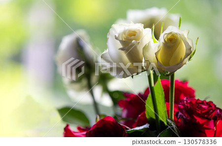 Beautiful bouquet of white and red roses on the window 130578336