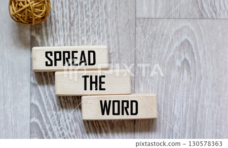 Wooden block with the text SPREAD THE WORD on a gray background Wooden block with the text SPREAD THE WORD on a gray background 130578363