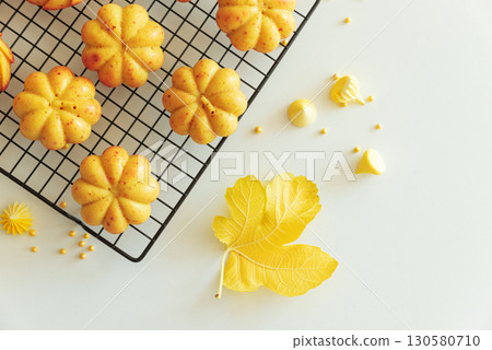 Autumn-Themed Mini pumpkin Cakes with Seasonal Decorations on White Background 130580710