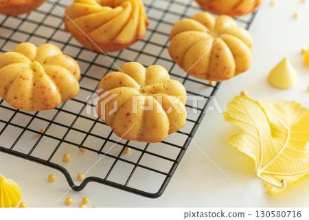 Autumn-Themed Mini pumpkin Cakes with Seasonal Decorations on White Background 130580716