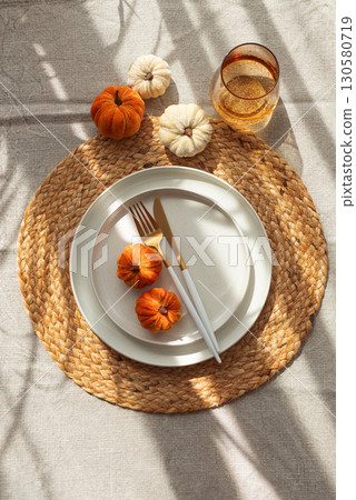 Autumn Table Setting with Decorative Pumpkins and Seasonal Leaves 130580719