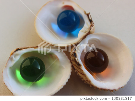 Three Colorful Glass Balls In Opened Pearl Mussels Isolated On White Three Colorful Glass Balls In Opened Pearl Mussels Isolated On White 130581517
