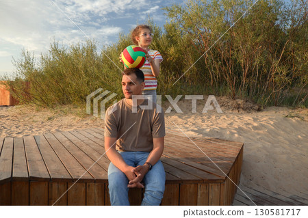 Father and daughter with ball on beach Father and daughter with ball on beach 130581717