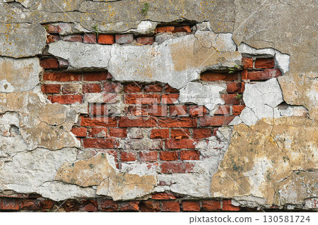 old brown brickwork with peeling plaster, wall 130581724