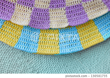 two crochet yellow and blue, violet squares in checkerboard pattern on green crochet background two crochet yellow and blue, violet squares in checkerboard pattern on green crochet background 130581735