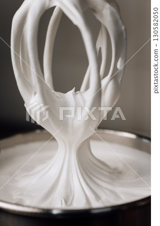 Freshly whipped marshmallow mixture on a whisk in a pastry kitchen, close-up Freshly whipped marshmallow mixture on a whisk in a pastry kitchen, close-up 130582050