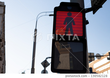 Red pedestrian traffic light shows dont walk signal, part of modern digital system ensuring safety for pedestrians in urban areas. Everyday life in contemporary cities 130582128