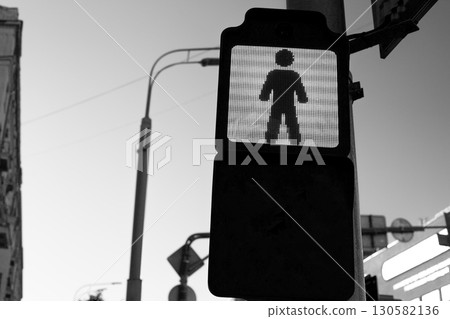 Pedestrian signal in black and white, emphasizing importance of road safety and traffic regulations. Image captures stillness and importance of waiting for the signal in urban environment Pedestrian signal in black and white, emphasizing importance of road safety and traffic regulations. Image captures stillness and importance of waiting for the signal in urban environment 130582136