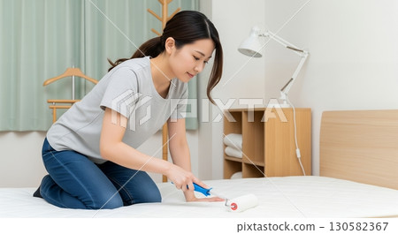 Woman cleaning the bed 130582367
