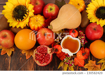 Thanksgiving banner, autumn background with apples, pomegranates, pumpkins, honey, grapes, flowers under sunflowers and leaves on wooden table, harvest concept, healthy natural food advertising Thanksgiving banner, autumn background with apples, pomegranates, pumpkins, honey, grapes, flowers under sunflowers and leaves on wooden table, harvest concept, healthy natural food advertising 130582420