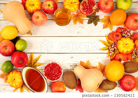Thanksgiving banner, autumn background with wreath of maple leaves, red rowan, pumpkin, pomegranate and apples on old wooden table, creative design template with space for text on screen Thanksgiving banner, autumn background with wreath of maple leaves, red rowan, pumpkin, pomegranate and apples on old wooden table, creative design template with space for text on screen 130582421