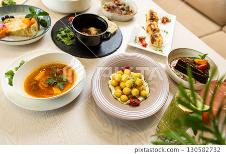 Traditional Middle Eastern dishes served on a white table in restaurant interior Traditional Middle Eastern dishes served on a white table in restaurant interior 130582732