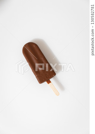 Chocolate ice cream bar on stick isolated on white background, minimal summer dessert Chocolate ice cream bar on stick isolated on white background, minimal summer dessert 130582781
