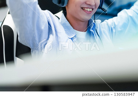 A boy engrossed in playing computer games with a gaming keyboard 130583947