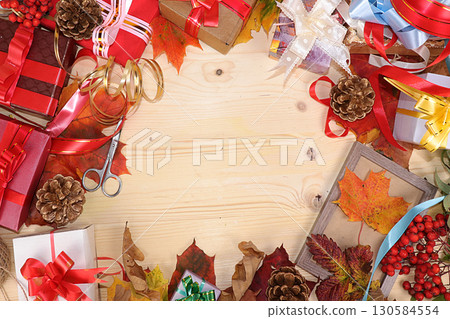 Thanksgiving, autumn background with seasonal maple leaves and gifts on a wooden background, top view, copy space, flat lay. Happy Thanksgiving concept, selective focus. Thanksgiving, autumn background with seasonal maple leaves and gifts on a wooden background, top view, copy space, flat lay. Happy Thanksgiving concept, selective focus. 130584554