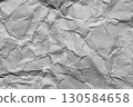 A textured light gray crumpled paper background with natural creases and folds. Ideal for design projects, digital graphics, or creative presentations requiring a vibrant 130584658