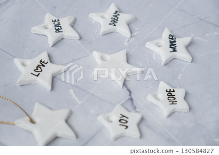 Christmas star with words Creator is using white air dry clay for making decor to Christmas tree holiday. Creating hobby recreation activity that involves fingers. DIY crafting 130584827