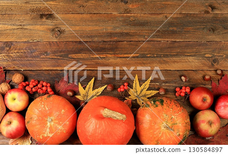 Happy Thanksgiving concept, greeting card, Autumn background with seasonal pears, pumpkins, apples, leaves and flowers on wooden background, copy space, Harvest, gifts of nature, selective focus. 130584897