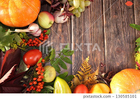 Frame of vegetables on a wooden background, top view, flat lay. Pumpkin, tomatoes, mountain ash, grapes on a festive autumn background, Thanksgiving concept 130585101