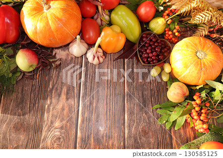 Autumn background and harvest in the village with seasonal berries, pumpkins, apples, rowan, grape and nature flowers on a wooden background, copy space, flat lay. Happy Thanksgiving Autumn background and harvest in the village with seasonal berries, pumpkins, apples, rowan, grape and nature flowers on a wooden background, copy space, flat lay. Happy Thanksgiving 130585125