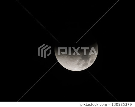 A full moon with about half of it darkened due to a lunar eclipse 130585379