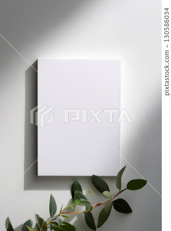 Mockup of a canvas and plant against a white wall and in the shadows Mockup of a canvas and plant against a white wall and in the shadows 130586034