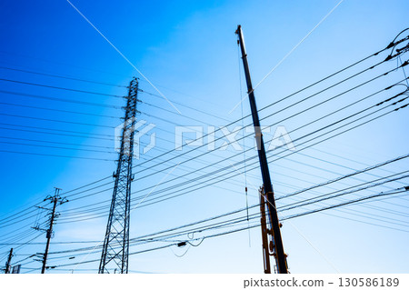 A crane arm and a power transmission tower stretching into the sky a-2 High saturation contrast 130586189