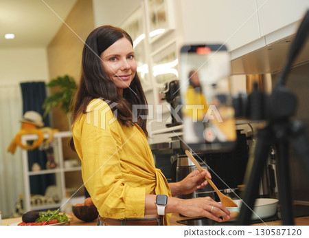 Young woman is broadcasting live from workshop how to prepare a vegetarian food Young woman is broadcasting live from workshop how to prepare a vegetarian food 130587120