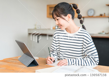 小學和國中女生使用平板電腦學習和做作業 130587138