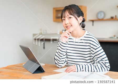 小學和國中女生使用平板電腦學習和做作業 130587141