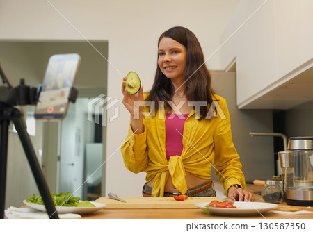 Young woman is broadcasting live from workshop how to prepare a vegetarian food Young woman is broadcasting live from workshop how to prepare a vegetarian food 130587350