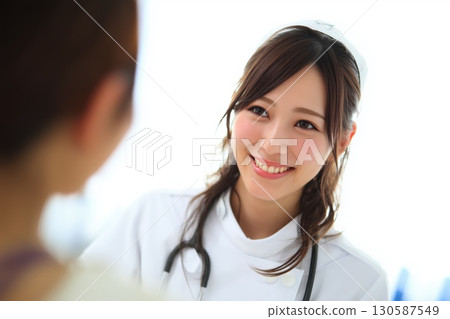 A dedicated young Japanese nurse working with a smile at the hospital 130587549