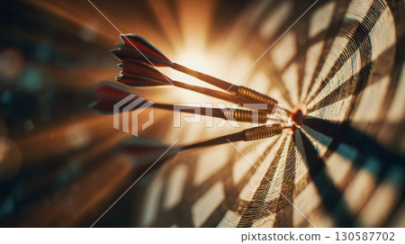 Close-up of three darts embedded in a dartboard with dramatic lighting and shadows 130587702