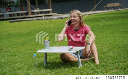 Young woman beading colorful bracelets outdoors in a park Young woman beading colorful bracelets outdoors in a park 130587735