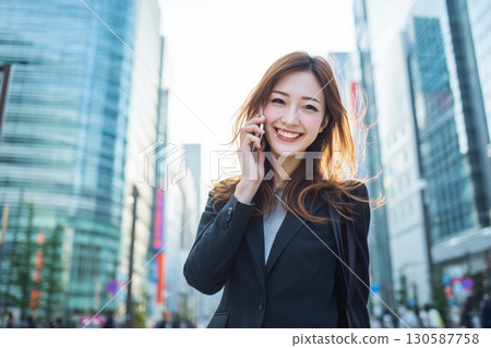 A young Japanese businesswoman walking briskly through an office district 130587758