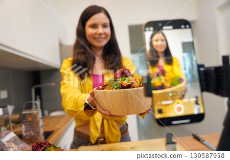 Young woman is broadcasting live from workshop how to prepare a vegetarian food Young woman is broadcasting live from workshop how to prepare a vegetarian food 130587958