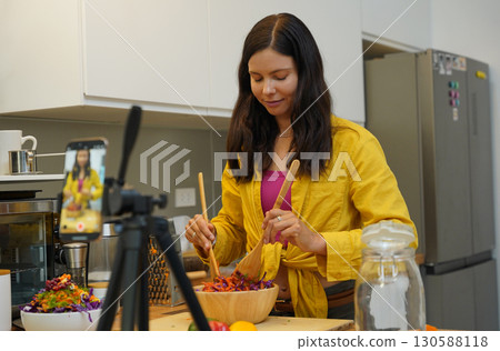 Young woman is broadcasting live from workshop how to prepare a vegetarian food Young woman is broadcasting live from workshop how to prepare a vegetarian food 130588118