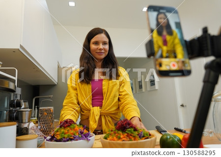 Young woman is broadcasting live from workshop how to prepare a vegetarian food Young woman is broadcasting live from workshop how to prepare a vegetarian food 130588295