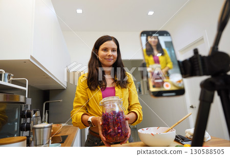 Young woman is broadcasting live from workshop how to prepare a vegetarian food Young woman is broadcasting live from workshop how to prepare a vegetarian food 130588505