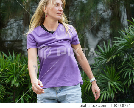 A woman is rollerblading gracefully on a road located in a park 130588735