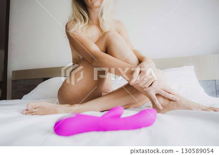 Sexy nude young woman with black mask and dildo posing in the bedroom 130589054