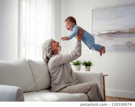 Happy grandmother lifting baby child playing in cozy home environment 130589074