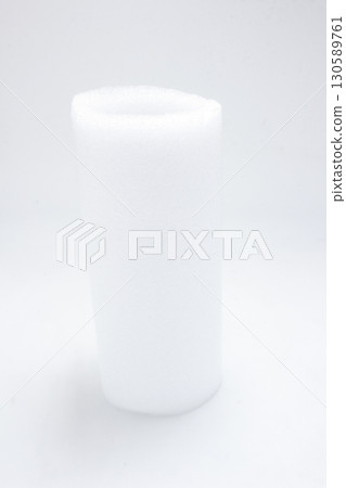 Soft Roll of White Foam Material Isolated on a Neutral Background 130589761