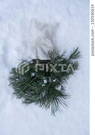 Reusable shopping bag with fir spruce green branches in snowy outdoor winter forest background. Merry Christmas and new year concept. Natural bouquet greeting card copy space 130590814