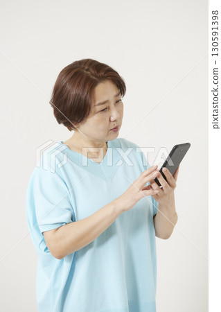 Senior woman operating a smartphone 130591398